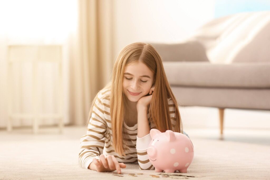 teen girl with piggy bank and money at home