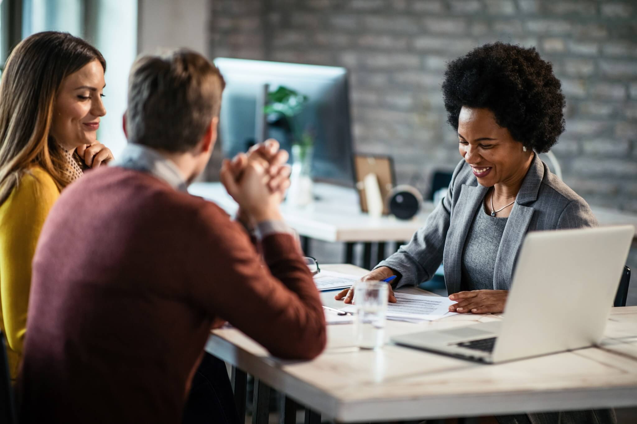 cheerful african american financial advisor on a meeting with a couple