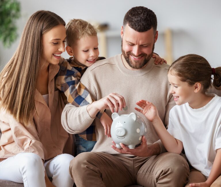 little girl and boy with their mom and dad putting coins in a piggy bank