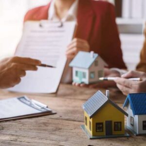 model homes sitting on a desk and bankers and clients discussing
