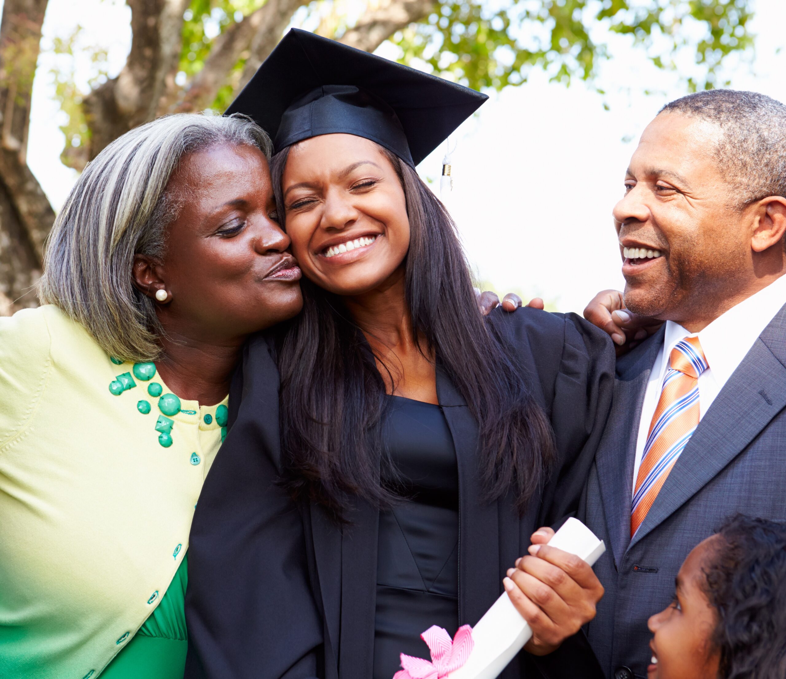 smiling graduating young women with her parents hugging her