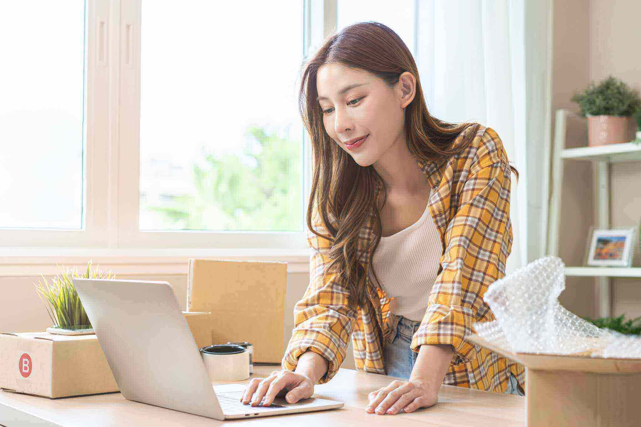 startup small business entrepreneur asian young woman using laptop computer check order purchase from web