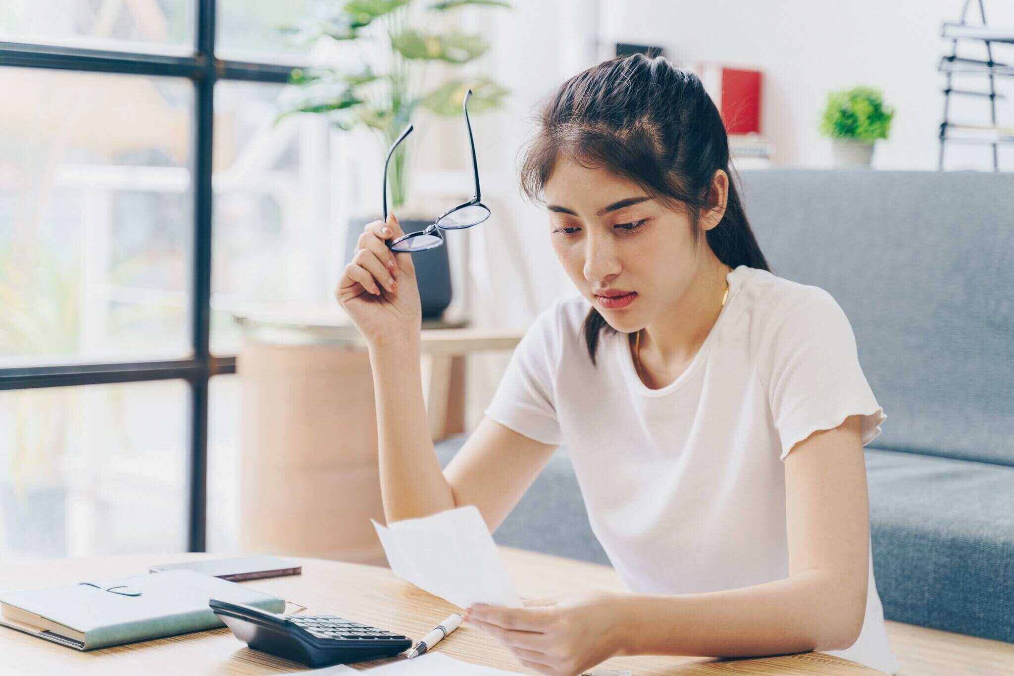 woman doing finance at home office with calculate expenses and savings