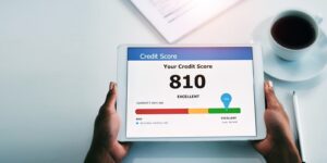 hands and tablet with good credit score in finance, banking or investment above on mockup at office