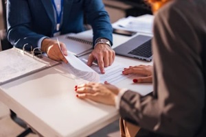 real estate agent closes the deal with the client and they sign the contract