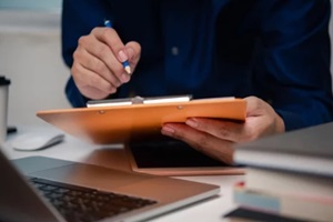 man holding clipboard with checklist employee workplace is reviewing documents