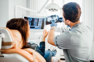 Dentist reviews x-ray scan with patient
