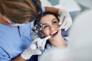 dentist with dental practice loan over shoulder view of patient 
