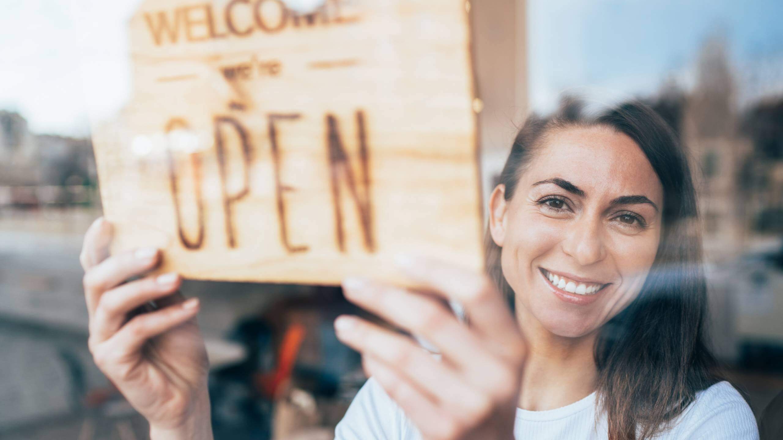 Woman holding an open sign